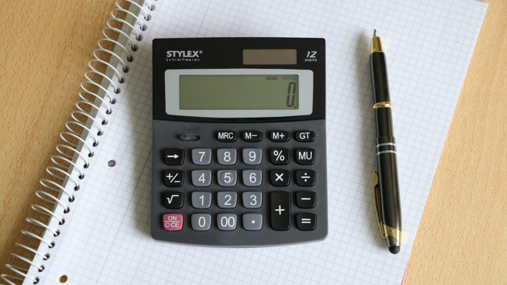 calculator and pen on notepad